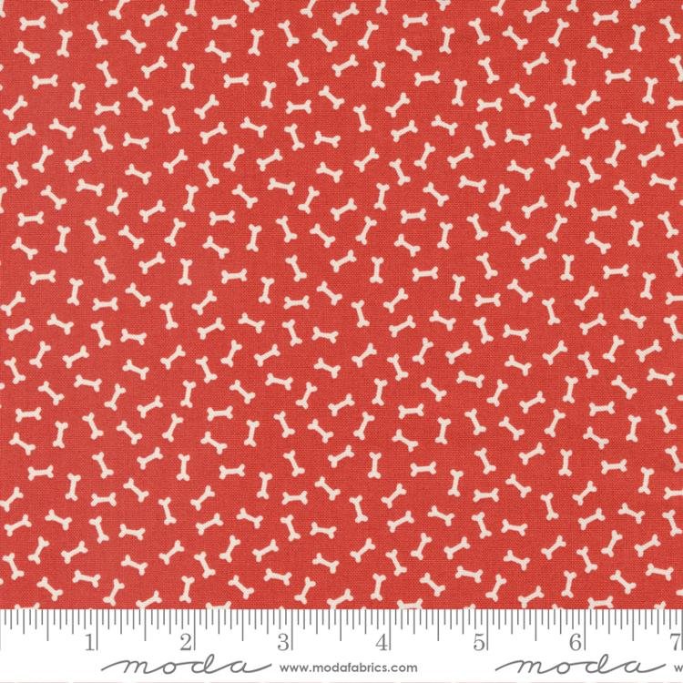 Red fabric with white dog bones on it.