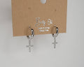CROSS HUGGIE HOOP EARRINGS.: Silver