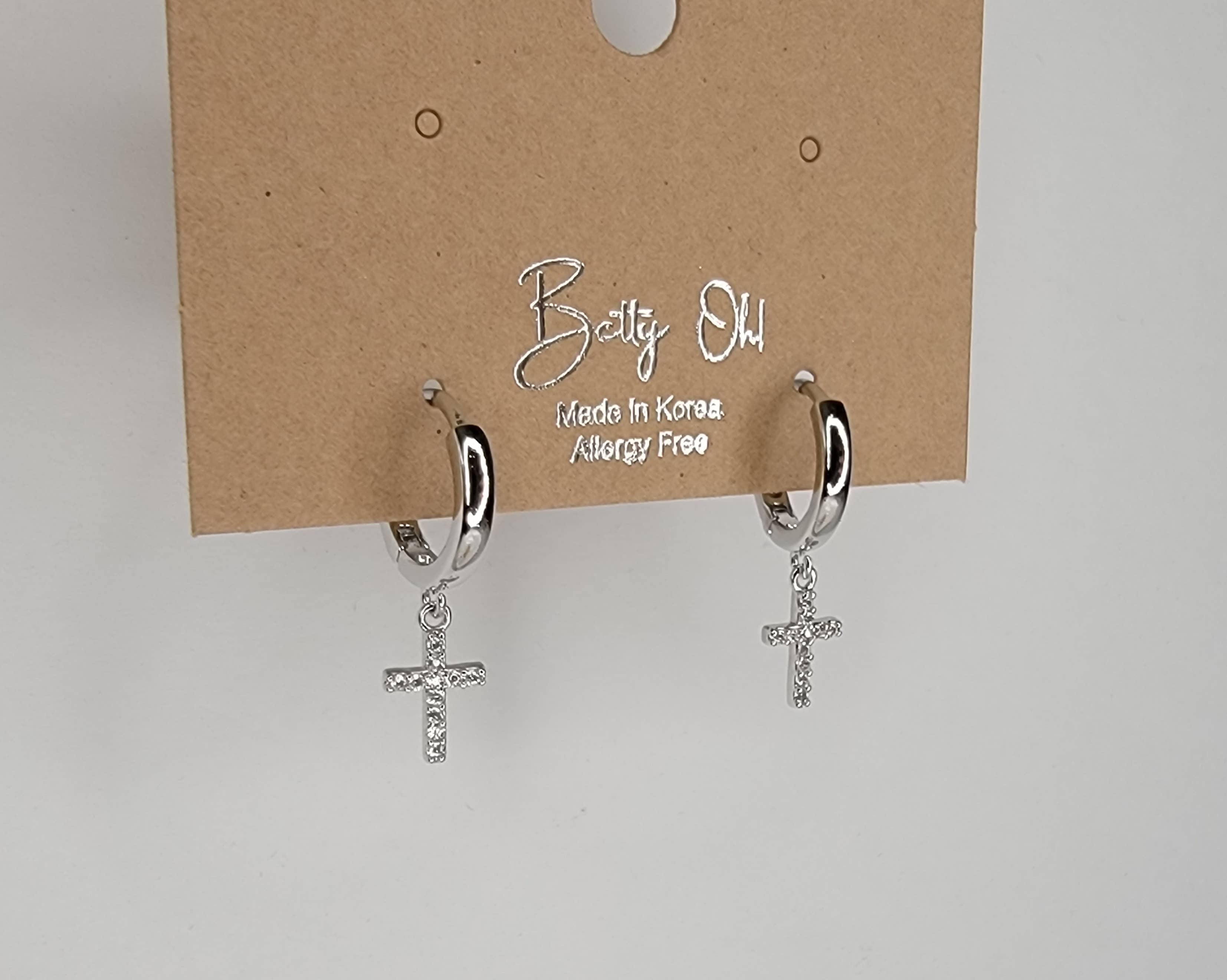 CROSS HUGGIE HOOP EARRINGS.: Silver